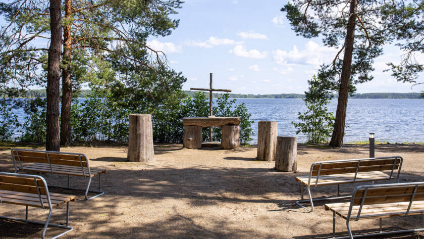 Penkkejä ja puinen alttari puisella ristillä Punkaharjun kirkkorannassa.