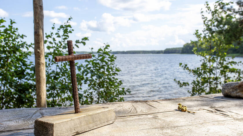 Pieni metallinen koristeristi puisella alttarilla Punkaharjun kirkkorannassa.